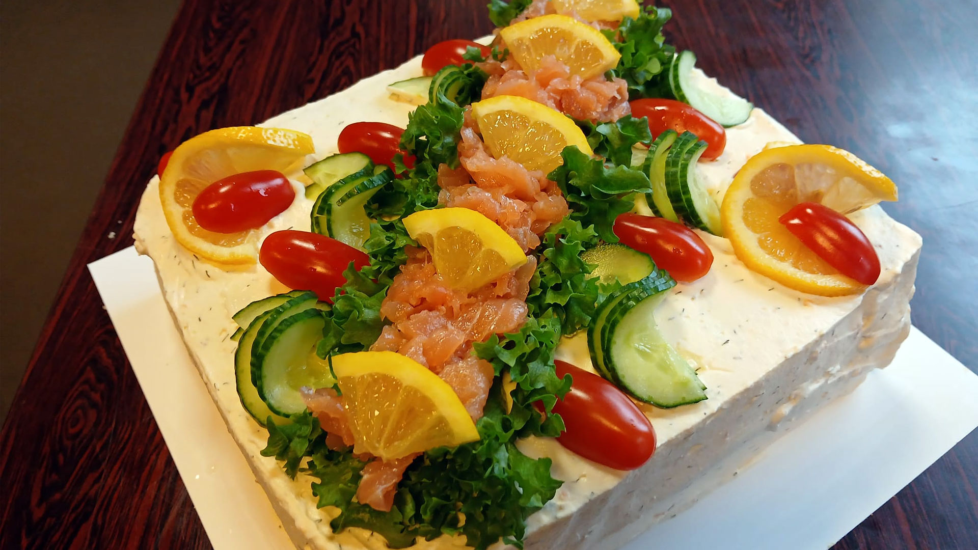 Voileipäkakku, jossa koristeena muun muassa lohta, sitruksia, kurkkua ja persiljaa.